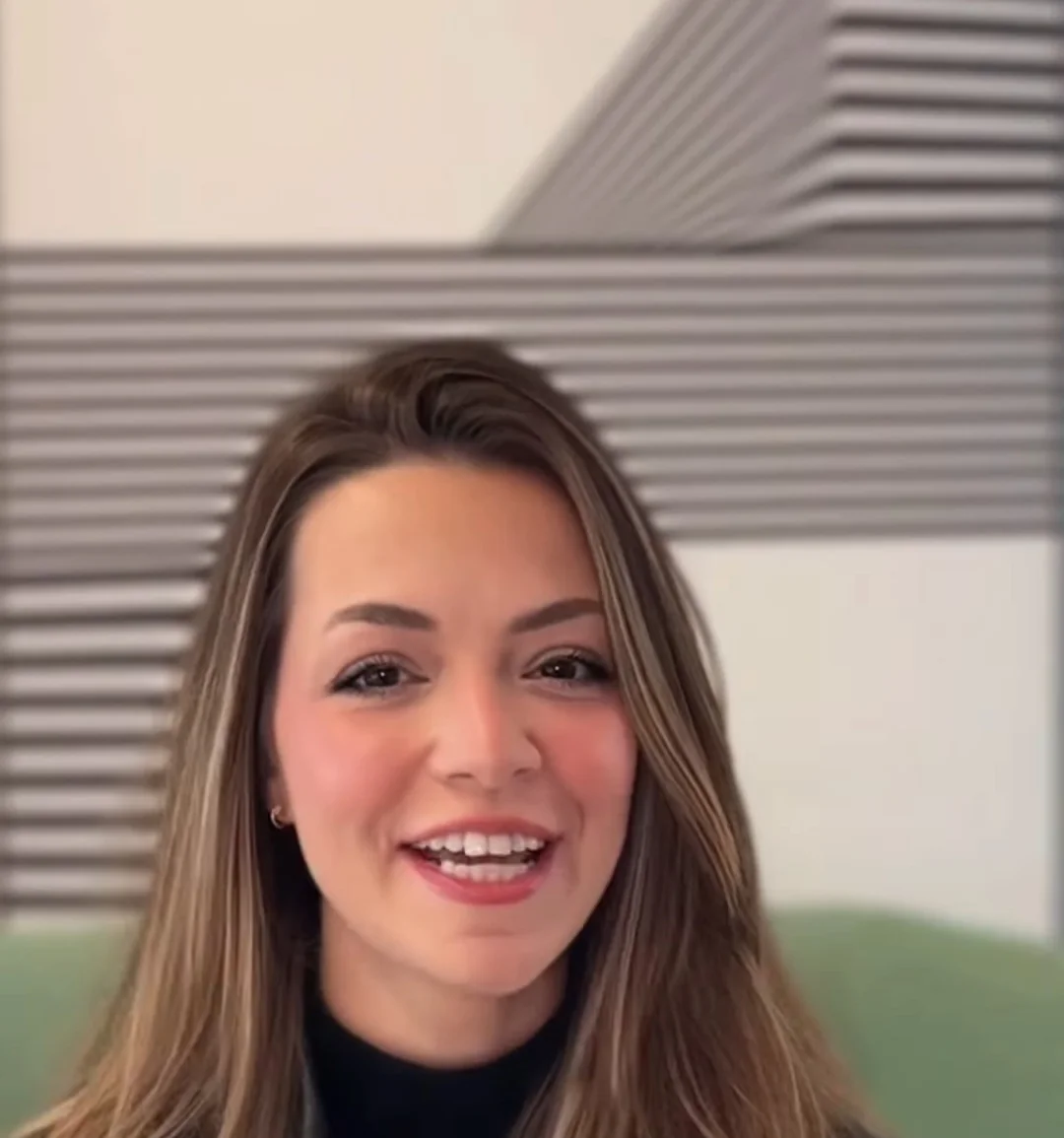 Dra. Letícia Fitipaldi de jaqueta de couro preta, sorrindo, gravando um vídeo de respostas às perguntas dos pais